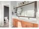 Well-lit bathroom featuring double sink vanity, large mirror, and shower, offering a functional and stylish space at 3848 S Coach House Dr, Gilbert, AZ 85297