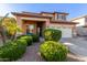 Inviting two-story home boasts a welcoming entrance, well-manicured shrubs, and a two-car garage at 3848 S Coach House Dr, Gilbert, AZ 85297