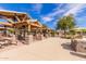 A charming outdoor kitchen area under a shaded pavilion with stone counters, picnic tables and grill for community gatherings at 3848 S Coach House Dr, Gilbert, AZ 85297