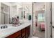 Bathroom featuring dual sinks, vanity storage, with doorway view to adjoining room at 4167 E Sierra Madre Ave, Gilbert, AZ 85296