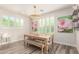 Cozy dining area with a wooden table, decorative chandelier, and white plantation shutters for natural light at 4167 E Sierra Madre Ave, Gilbert, AZ 85296