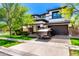 Beautiful two-story home featuring a modern black and white facade, green lawn, and a paved driveway at 4167 E Sierra Madre Ave, Gilbert, AZ 85296