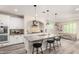 Stylish kitchen boasts white cabinets, a large granite island with seating, and stainless steel appliances at 4167 E Sierra Madre Ave, Gilbert, AZ 85296