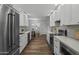 Galley kitchen featuring white cabinets, stainless steel appliances, and modern countertops at 4228 N 87Th St, Scottsdale, AZ 85251
