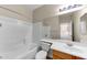 Bright bathroom featuring tile surround tub, toilet, and vanity at 4234 S 62Nd Ln, Phoenix, AZ 85043