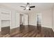Spacious bedroom featuring ceiling fan, rich flooring and walk-in closet and additional rooms beyond white doors at 439 N Cobblestone St, Gilbert, AZ 85234