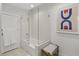 Bathroom with tiled shower, patterned art, and a woven stool at 4446 E Camelback Rd # 104, Phoenix, AZ 85018