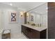 Bathroom with dual sinks, framed mirrors, and modern lighting at 4446 E Camelback Rd # 104, Phoenix, AZ 85018