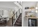 Modern staircase with glass railings, open to the kitchen and dining area, next to the bar at 4446 E Camelback Rd # 104, Phoenix, AZ 85018