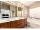 Bathroom with double sinks, a large mirror, and a bathtub at 4604 E Summerhaven Dr, Phoenix, AZ 85044
