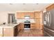 Bright kitchen featuring stainless steel appliances, tile floors, and light wood cabinets at 4604 E Summerhaven Dr, Phoenix, AZ 85044