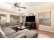 Comfortable living room with a plush sectional couch, ceiling fan, and access to the backyard at 4604 E Summerhaven Dr, Phoenix, AZ 85044
