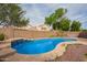 Backyard pool with stone coping, and a small waterfall feature amidst mature landscaping and privacy fence at 4604 E Summerhaven Dr, Phoenix, AZ 85044