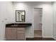 Bathroom with dark countertop vanity, mirror, and a view into the closet at 4612 W Waltann W Ln, Glendale, AZ 85306