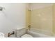 A compact bathroom with a toilet, bathtub, and yellow-tiled walls at 4612 W Waltann W Ln, Glendale, AZ 85306