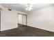 A bedroom with a carpeted floor, ceiling fan, and a mirror door to the closet at 4612 W Waltann W Ln, Glendale, AZ 85306