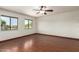 Cozy bedroom with hardwood floors, two large windows, and a ceiling fan at 4612 W Waltann W Ln, Glendale, AZ 85306
