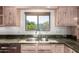 Close up of the kitchen sink, granite countertops, and custom cabinetry at 4612 W Waltann W Ln, Glendale, AZ 85306