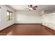 Bright living room featuring dark hardwood floors, a large window, a ceiling fan and a built-in entertainment center at 4612 W Waltann W Ln, Glendale, AZ 85306