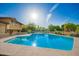 Relaxing backyard oasis featuring a sparkling pool, lush landscaping, and sunny skies at 4612 W Waltann W Ln, Glendale, AZ 85306