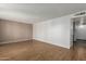 Spacious living room with wood-look tile flooring and neutral paint, leading to other rooms at 4728 N 61St Ave, Phoenix, AZ 85033