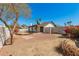 Backyard with desert landscaping, block fencing, covered patio and mature tree at 4901 W Augusta Cir, Glendale, AZ 85308