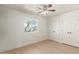 An inviting bedroom features a ceiling fan, natural light from a window, and a convenient closet at 4901 W Augusta Cir, Glendale, AZ 85308