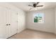 Bright bedroom features a ceiling fan, closet, and sunny window offering a comfortable living space at 4901 W Augusta Cir, Glendale, AZ 85308