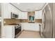 Bright kitchen with stainless steel appliances, modern backsplash, and white cabinetry at 4901 W Augusta Cir, Glendale, AZ 85308