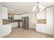 Spacious kitchen features stainless steel appliances, white cabinets, and a modern chandelier at 4901 W Augusta Cir, Glendale, AZ 85308