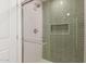 Modern shower featuring glass doors, a rainfall shower head, and green tiled walls at 4901 W Augusta Cir, Glendale, AZ 85308