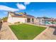 Backyard featuring a pool, artificial turf, and solar panels on the roof at 5115 W Kings Ave, Glendale, AZ 85306
