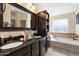 Bathroom with granite countertop, dark vanity, soaking tub and large mirror at 5115 W Kings Ave, Glendale, AZ 85306