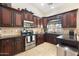 Stylish kitchen featuring rich wood cabinetry, granite countertops, stainless steel appliances, and tile flooring at 5115 W Kings Ave, Glendale, AZ 85306
