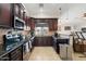 Kitchen with dark wood cabinets, granite countertops, tiled backsplash, and stainless steel appliances at 5115 W Kings Ave, Glendale, AZ 85306