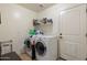 Functional laundry room with white washer and dryer, storage shelves, and ample space at 5115 W Kings Ave, Glendale, AZ 85306