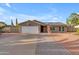 Charming single-story home featuring a brick facade, two-car garage, and manicured landscaping at 6126 W Sweetwater Ave, Glendale, AZ 85304