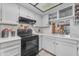 Bright kitchen boasting white cabinets, black appliances, and functional open shelving at 6126 W Sweetwater Ave, Glendale, AZ 85304