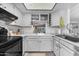Well-lit kitchen featuring white cabinets, light countertops, and black appliances at 6126 W Sweetwater Ave, Glendale, AZ 85304