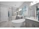 Bright bathroom with a standalone tub, double sinks, and an elegant glass shower with pristine finishes and natural light at 722 W Claremont St, Phoenix, AZ 85013