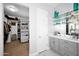 Bright bathroom with a gray vanity, marble floors and glass shelves for decoration at 722 W Claremont St, Phoenix, AZ 85013