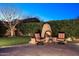 Backyard fireplace with comfortable seating and manicured green lawn at 722 W Claremont St, Phoenix, AZ 85013