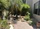 Tranquil backyard featuring lush landscaping, a charming water feature and a paved walkway at 7318 E Woodsage Ln, Scottsdale, AZ 85258