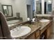 Bathroom has double sinks with granite countertops and framed mirrors with a jetted tub visible at 7318 E Woodsage Ln, Scottsdale, AZ 85258