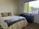 Bright bedroom featuring a comfortable bed, dark wood furniture, and a sunlit window with peaceful outdoor views at 7318 E Woodsage Ln, Scottsdale, AZ 85258