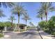 Gated community entrance lined with mature palm trees and manicured landscaping under a clear blue sky at 7318 E Woodsage Ln, Scottsdale, AZ 85258