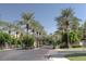 Gated community entrance lined with mature palm trees and manicured landscaping offering a secure and appealing environment at 7318 E Woodsage Ln, Scottsdale, AZ 85258