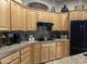 Well-equipped kitchen with wood cabinets, granite countertops, and black appliances at 7318 E Woodsage Ln, Scottsdale, AZ 85258