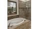 Luxurious main bath features a soaking tub and a glass-enclosed shower with designer tile at 7318 E Woodsage Ln, Scottsdale, AZ 85258