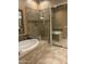 Elegant bathroom with a soaking tub, glass-enclosed shower, and tiled flooring at 7318 E Woodsage Ln, Scottsdale, AZ 85258